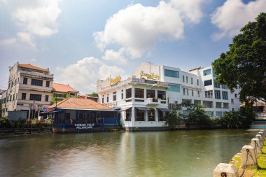 Malacca, Malaysia - August 10, 2022: Along the Melaka river with the old brightly painted houses. Bars and restaurants line the course of the river. Long Exposure capture smooths silky water.