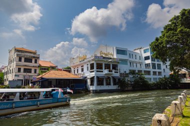 Malacca, Malaysia - August 10, 2022: Along the Melaka river with the old brightly painted houses. Bars and restaurants line the course of the river. Long Exposure capture smooths silky water.