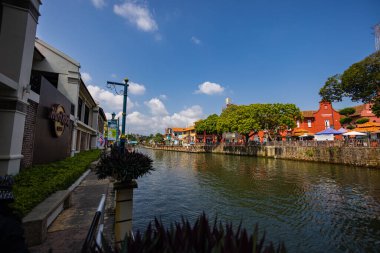 Malacca, Malaysia - August 10, 2022: Along the Melaka river with the old brightly painted houses. Bars and restaurants line the course of the river. Long Exposure capture smooths silky water.