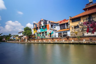Malacca, Malaysia - August 10, 2022: Along the Melaka river with the old brightly painted houses. Bars and restaurants line the course of the river. Long Exposure capture smooths silky water.