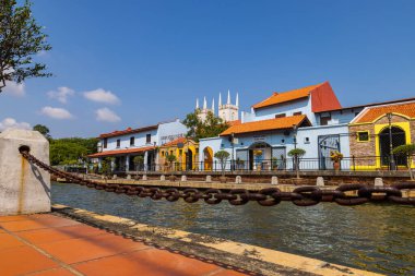 Malacca, Malaysia - August 10, 2022: Along the Melaka river with the old brightly painted houses. Bars and restaurants line the course of the river. Long Exposure capture smooths silky water.