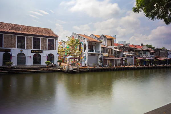 Malacca, Malaysia - August 10, 2022: Along the Melaka river with the old brightly painted houses. Bars and restaurants line the course of the river. Long Exposure capture smooths silky water.