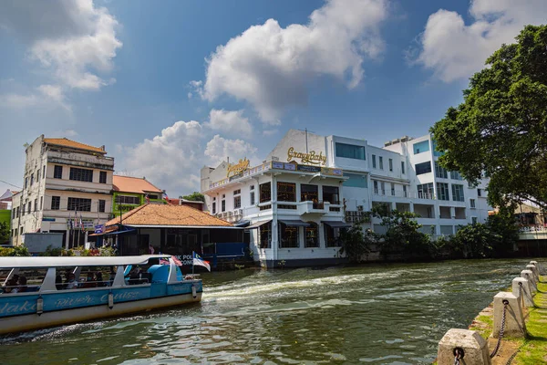 Malacca, Malaysia - August 10, 2022: Along the Melaka river with the old brightly painted houses. Bars and restaurants line the course of the river. Long Exposure capture smooths silky water.