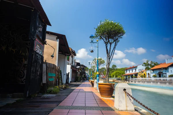 Malacca, Malaysia - August 10, 2022: Along the Melaka river with the old brightly painted houses. Bars and restaurants line the course of the river. Long Exposure capture smooths silky water.