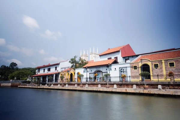 Malacca, Malaysia - August 10, 2022: Along the Melaka river with the old brightly painted houses. Bars and restaurants line the course of the river. Long Exposure capture smooths silky water.