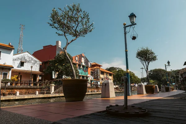 Malacca, Malaysia - August 10, 2022: Along the Melaka river with the old brightly painted houses. Bars and restaurants line the course of the river. Long Exposure capture smooths silky water.