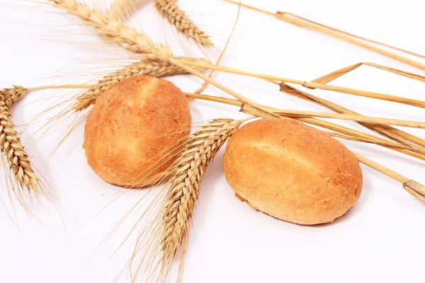 Bread bun and stalks of wheat — Stock Photo, Image