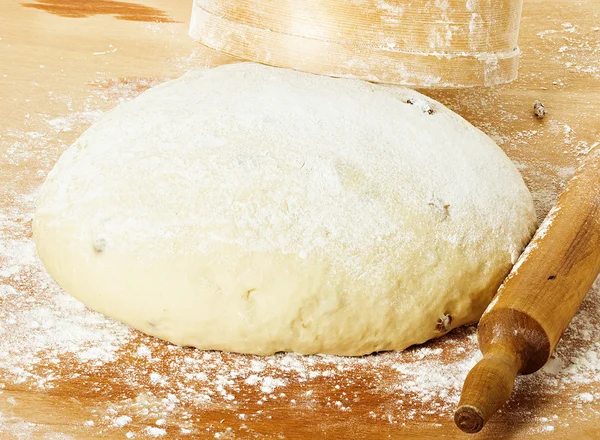 dough with rolling pin on floured table top view