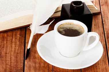 bir tüy kalem ve ahşap zemin üzerinde InkWell kahve