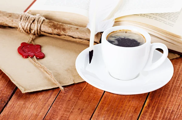 Cup of coffee with a quill pen and inkwell on wooden background — Stock Photo, Image