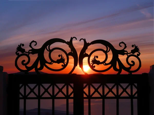 Sonnenuntergang durch Eisentor auf einer Klippe — Stockfoto