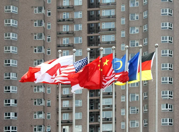 Banderas multinacionales frente a un edificio alto — Foto de Stock