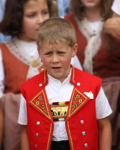 Un chico con traje suizo tradicional es yodeling — Foto de Stock