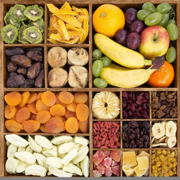 Frutos secos com frutas frescas em uma caixa de madeira — Fotografia de Stock