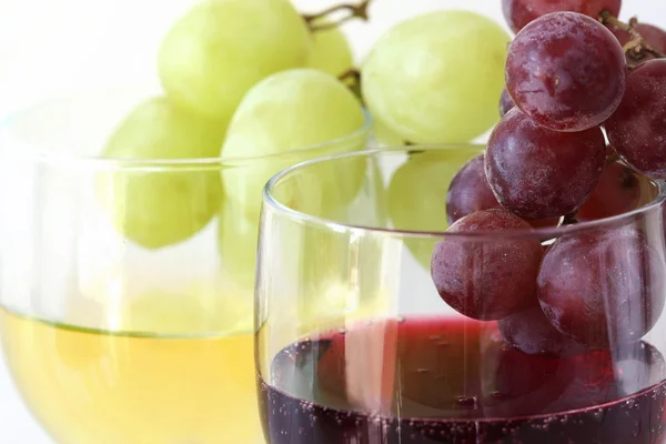 Green and red grapes on the white and red wine glasses — Stock Photo, Image