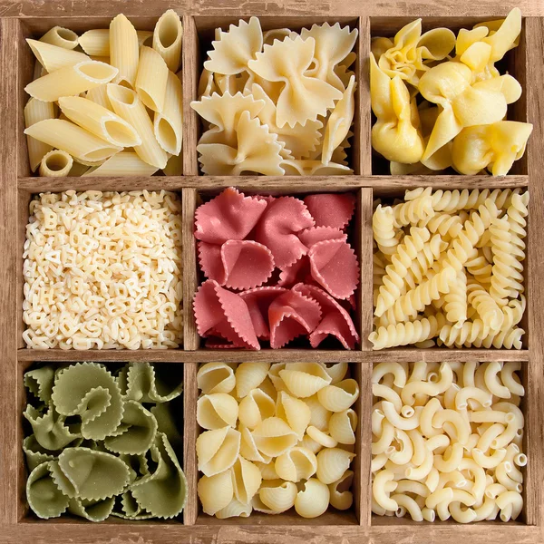 Geassorteerde pasta's in houten kist — Stockfoto