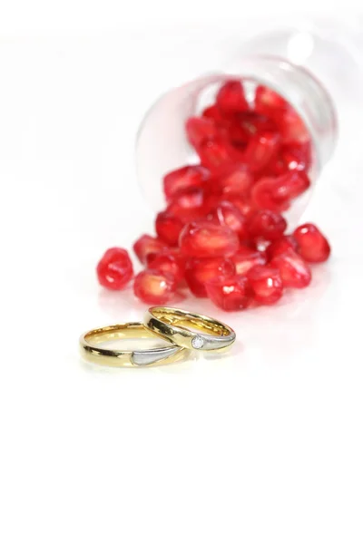 Semillas de granada y anillos de matrimonio — Foto de Stock