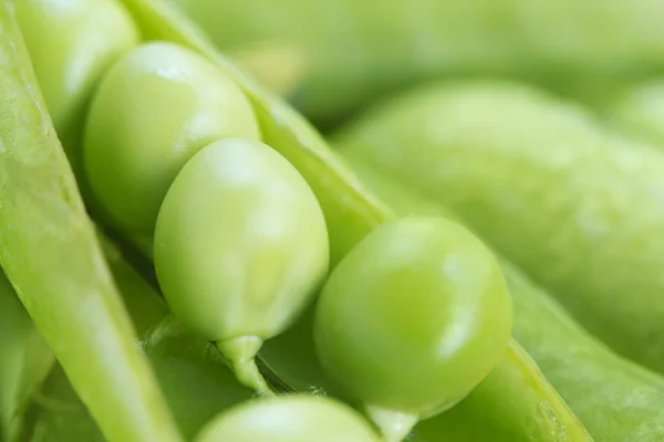 Grüne Erbsen in einer Erbsenschale — Stockfoto