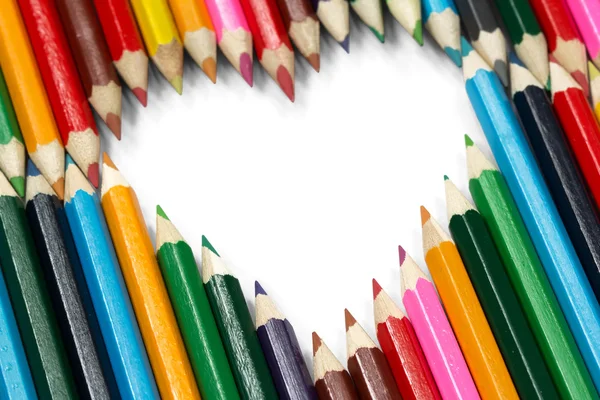Lápices de colores formando una forma de corazón volador — Foto de Stock