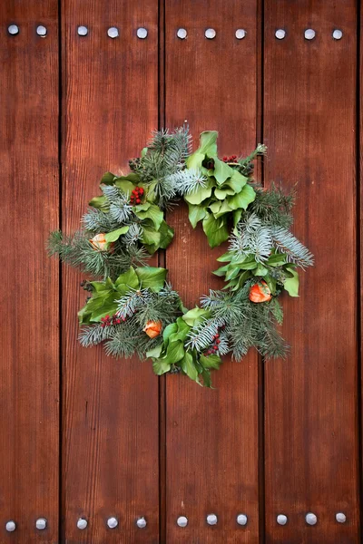 Dörrkrans på röd trädörr för juldekoration — Stockfoto