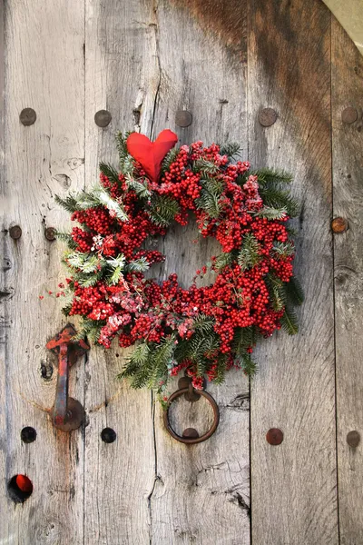 Vánoční věnec na staré dřevěné dveře — Stock fotografie