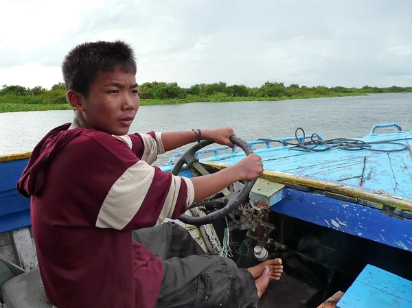 Um menino de escola dirige um barco com motor meramente funcional — Fotografia de Stock