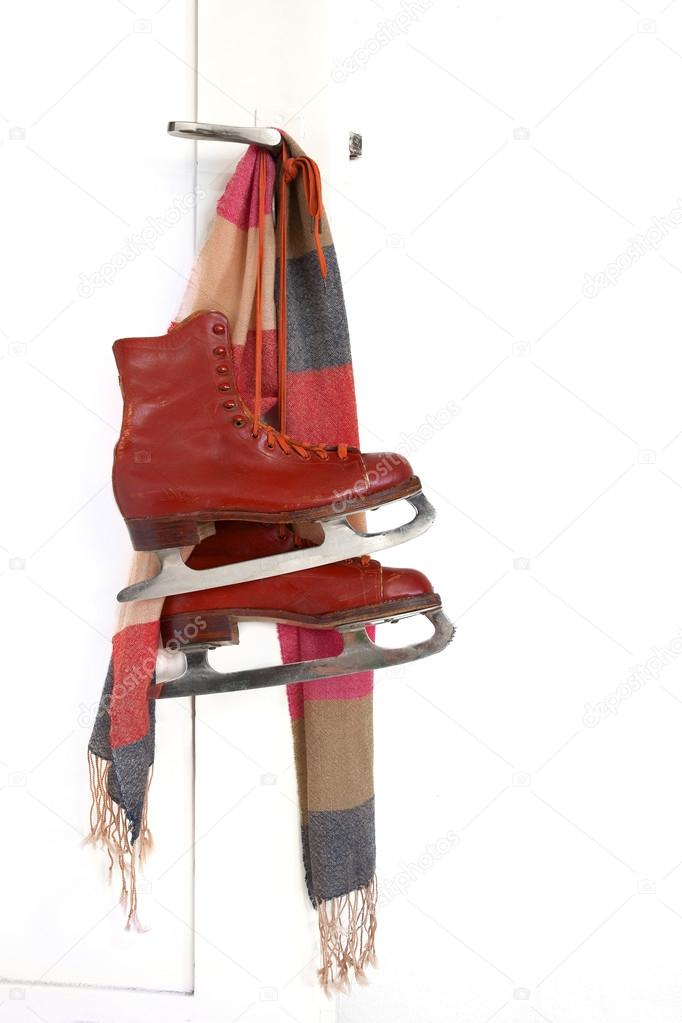 Lady skates and colorful scarf hanging on the door