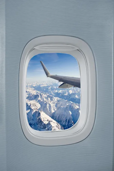 Airplane window with view over the Alps — Stock Photo, Image