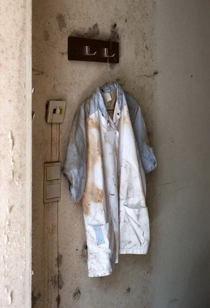Egy régi munkáskabát egy elhagyatott műhelyben. — Stock Fotó
