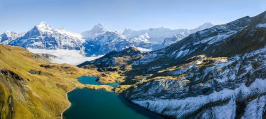 Grindelwald 'ın ilk tepesinde Wetterhorn, Schreckhorn ve Eiger' in ünlü Alpler Zirvesi ile birlikte Bachalpsee üzerindeki hava manzarası..