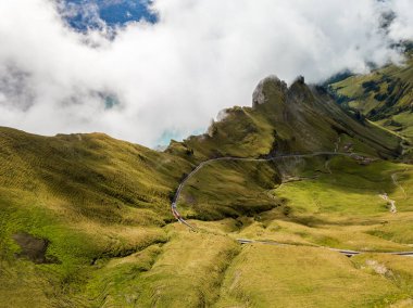 Brienzer Rothorn buhar treninin arka planda Dirrengrind uçurumu ve Brienz Gölü bölgesinden yükselen sonbahar sisi ile zirveye yükselen görüntüsü.