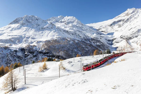 スイス アルプ グラム 2005年11月5日 2021年 昭和26年 ラティアン鉄道の赤い列車がアルプグラム高速道路で180度のカーブで線路を通っている パルプのピークは背景にあります — ストック写真