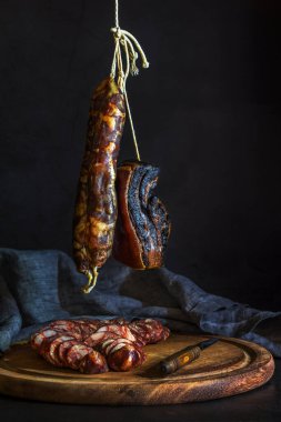Geleneksel olarak Asya ülkelerinde yeni yıl festivali için hazırlanan keten peçeteyle ev yapımı sosisleri asmak ve kesmek - koyu ve kasvetli bir ton