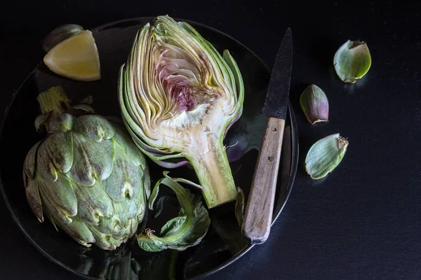 Las Alcachofas Frescas Cortan Mitad Con Limón Cuchillo Tono Oscuro —  Fotos de Stock