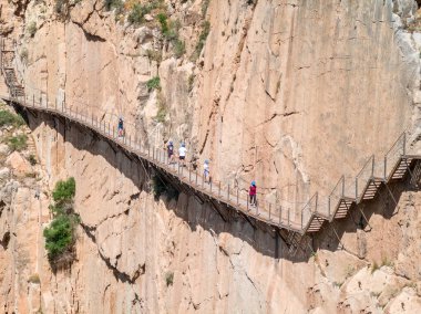 El Chorro, İspanya - 28 Mayıs. 2022: Malaga 'daki Caminito del Rey' i bitirdikten sonra Gaitanes Boğazı 'ndan çıkan yürüyüşçüler. 2015 'teki tadilattan önce dünyanın en tehlikeli yokuşu olmuştu.-
