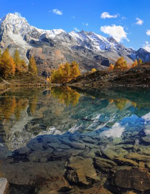 Dent de Veisivi ve Dent di Perroc tepelerinin yansımasıyla Canton Valais 'teki Arolla Gölü' nün Bleu Gölü 'nün rengarenk sonbahar mevsiminde.