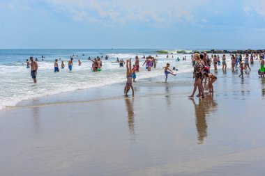 BELMAR, NEW JERSEY-AĞUSTOS 1 - 1 Ağustos 2015 Belmar New Jersey 'de kalabalık bir plajda bir kız amuda kalkıyor.