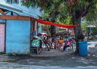 CANARIES, ST LUCIA -30 Nisan - Kadınlar 30 Nisan 2022 'de Kanarya, St Lucia' da satılık eşyalarla gölgede serinliyor.