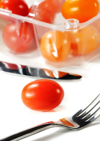 Garfo e faca com tomate cereja — Fotografia de Stock
