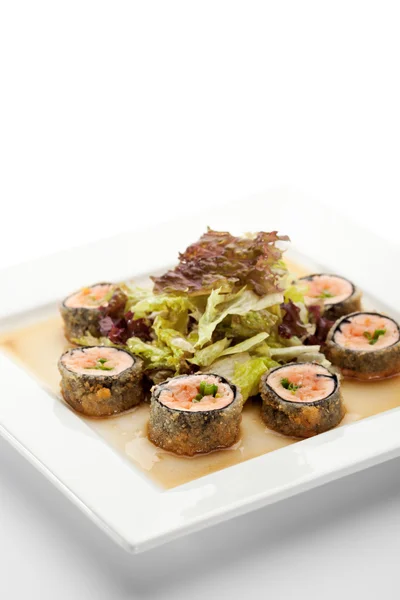 Cozinha Japonesa - Rolo de Sushi frito com salmão e alface no interior. Servido com folha de salada e molho — Fotografia de Stock