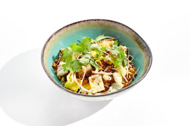 Geleneksel Çin yemeği - yumurta ve sebzeli kızarmış pirinç. Beyaz arka planda pirinçli Asya tavası ve doğranmış omlet. Yumurtalı Nasi Goreng izole edilmiş arka planda gölgeli