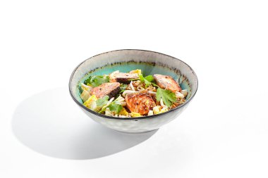 Geleneksel Asya yemeği. Yumurtalı, sebzeli ve somonlu pilav. Beyaz arka planda pilav, yumurta ve balıklı Pan Asya tavası. Somon balıklı Nasi goreng izole edilmiş arka planda gölgeli