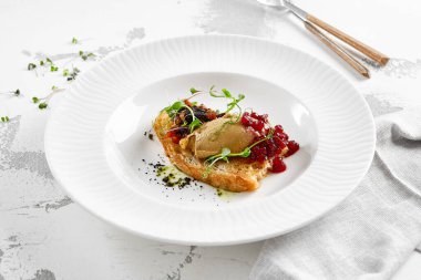 Kızarmış üzümlü kızarmış ekmek ve mikro yeşil tavuk ciğeri ezmesi. Beyaz tabakta tavuklu börek. Lezzetli aperatif, tost üzerine kaz ciğeri. Köy tarzında reçelli ciğer ezmesi.