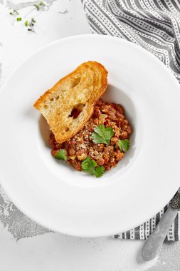 Beyaz tabakta Gürcü lobisi ve ekmek. Soslu ve baharatlı geleneksel Gürcü yemeği. Gürcü mutfağından vejetaryen aperatifi. Kafkas lobisi restoran menüsünde. Vejetaryen yemeği