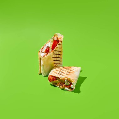 Sebzeli Shawarma ve yeşil arka planda et. Shawarma 'lı çağdaş poster. Doner kebabı çok az pişmiş. Sokak yemekleri konsepti. Abur cubur tasarımı. Asgari fast food menüsü