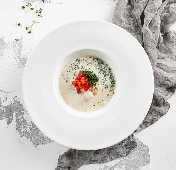 Fish creamy soup in norwegian style. Finnish fish soup with tomato, dill and creamy. Scandinavian food - salmon creamy soup. Seafood chowder with vegetables and fish. Norwegian cuisine