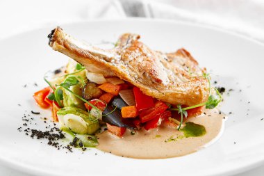 Biftek, sebze, garnitür ve sos. Kemikli domuz pirzolası. Köy tarzında ana yemek.