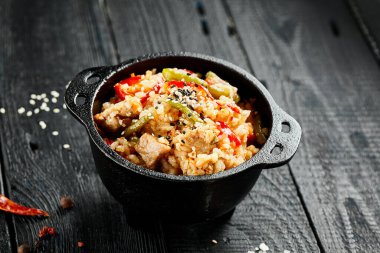 Tavuklu pilav. Asya yemeği. Sebzeli kızarmış pilav, yumurta ve tavuk. Siyah ahşap arka planda Wok menüsü. Geleneksel Çin yemekleri