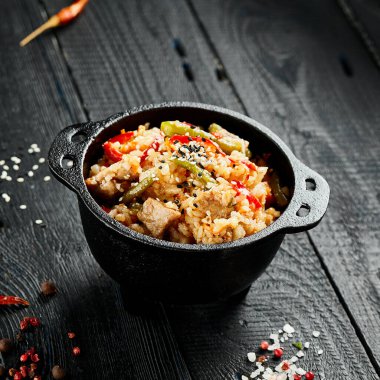 Tavuklu pilav. Asya yemeği. Sebzeli kızarmış pilav, yumurta ve tavuk. Siyah ahşap arka planda Wok menüsü. Geleneksel Çin yemekleri