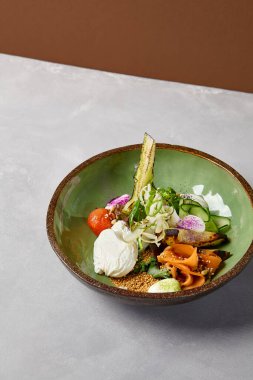 Somon, avokado, brokoli, sebze ve yumurta ile ev yapımı seramik tabakta salata kasesi. Modern servis takımında somon, brokoli ve kinoa ile Buda kasesi. Beton zeminde modern seramik bulaşık takımı